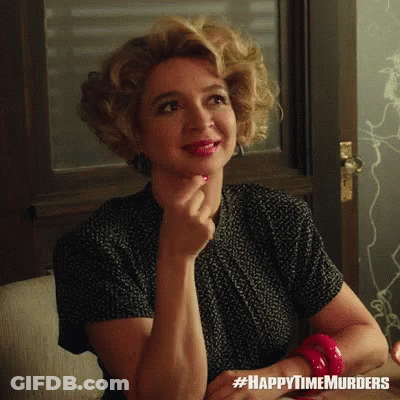 A Woman Sitting On A Couch With #Happytimemurders Written On The Bottom Right GIF