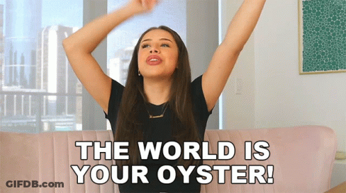 A Woman Sitting On A Couch With Her Arms Outstretched And The Words " The World Is Your Oyster " Above Her GIF