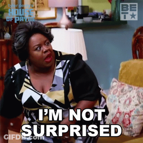A Woman Sitting On A Couch With The Words I 'M Not Surprised On Her Face GIF