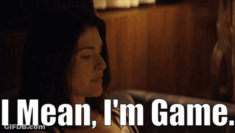 A Woman Sitting On A Couch With The Words " I Mean I 'M Game " Behind Her GIF