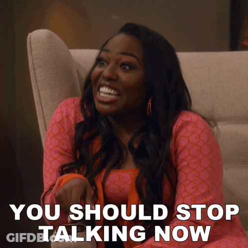 A Woman Sitting On A Couch With The Words " You Should Stop Talking Now " Written Below Her GIF