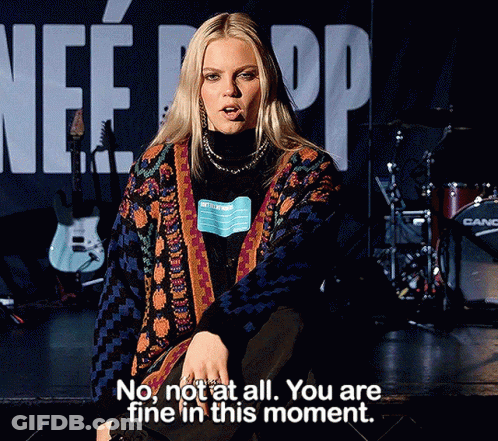 A Woman Sitting On A Stage With The Words " No Not At All You Are Fine In This Moment " Written Below Her GIF