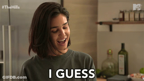 A Woman Smiles And Says I Guess In A Kitchen GIF
