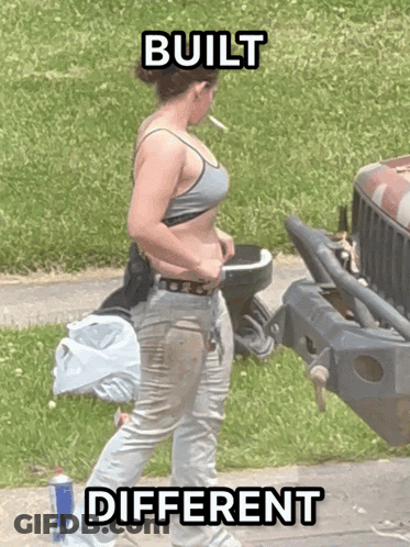 A Woman Smoking A Cigarette In Front Of A Jeep With The Words Built Different Written On The Bottom GIF
