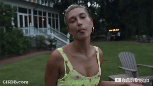 A Woman Smoking A Cigarette In Front Of A Youtube Originals Advertisement GIF
