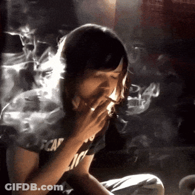 A Woman Smoking A Cigarette Wearing A Black Shirt That Says Escape GIF