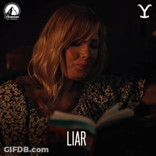 A Woman Smoking A Cigarette While Reading A Book Titled Liar GIF