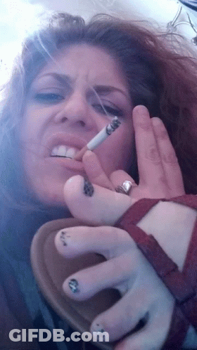 A Woman Smoking A Cigarette With A Ring On Her Left Hand GIF