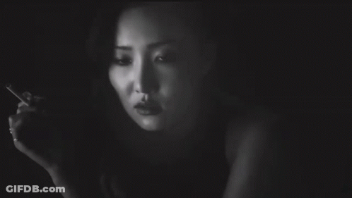 A Woman Smoking A Cigarette With A Tattoo On Her Arm That Says I Love You GIF