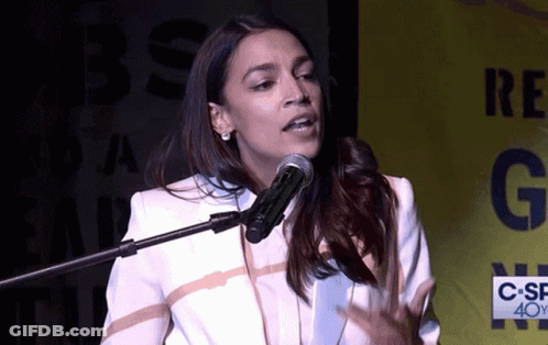 A Woman Speaking Into A Microphone In Front Of A Sign That Says C-Sf 40Y GIF