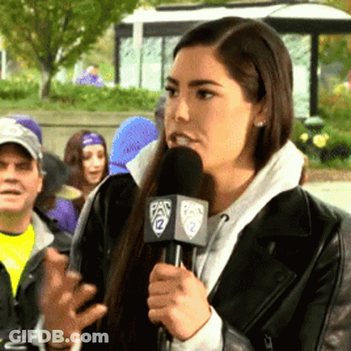A Woman Speaking Into A Microphone With The Number 12 On The Side GIF