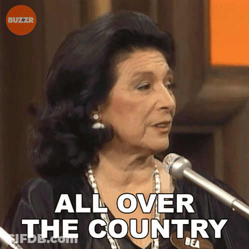 A Woman Speaking Into A Microphone With The Words " All Over The Country " Behind Her GIF