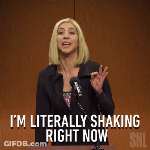 A Woman Speaking Into A Microphone With The Words " I 'M Literally Shaking Right Now " Above Her GIF