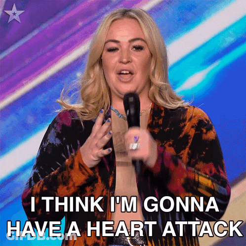 A Woman Speaking Into A Microphone With The Words " I Think I 'M Gonna Have A Heart Attack " Below Her GIF