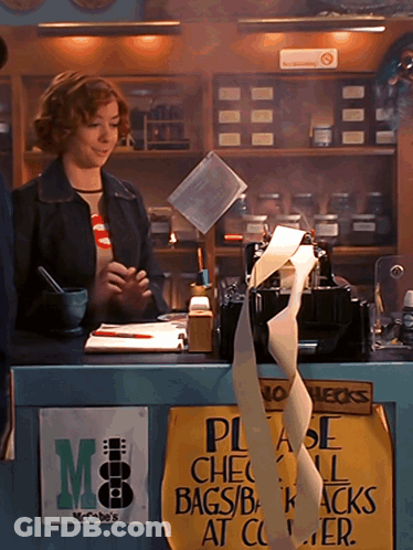 Woman Behind Counter With Please Check Bags Sign GIF