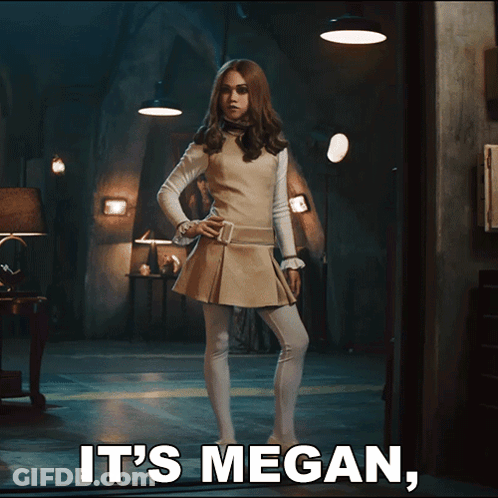 A Woman Standing In A Dark Room With The Words It 'S Megan Below Her GIF