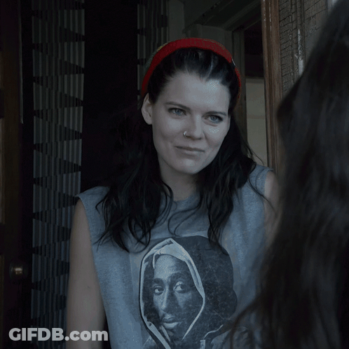 A Woman Standing In A Doorway With A Headband On GIF