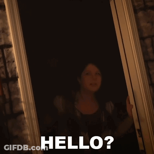 A Woman Standing In A Doorway With The Words Hello Written On The Bottom GIF