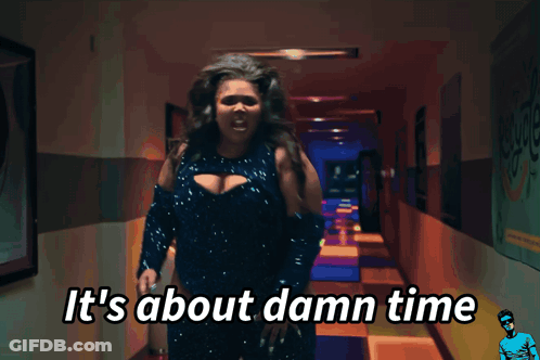 A Woman Standing In A Hallway With The Words It 'S About Damn Time GIF