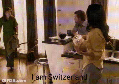 A Woman Standing In A Kitchen With The Words I Am Switzerland On The Bottom GIF