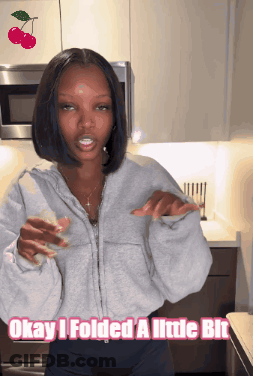 A Woman Standing In A Kitchen With The Words Okay I Folded A Little Bit Above Her GIF
