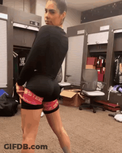 A Woman Standing In A Locker Room Wearing A Pair Of Shorts That Say Steel GIF