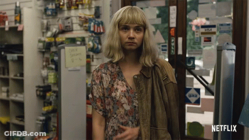 A Woman Standing In A Store With A Netflix Logo On The Bottom Right GIF