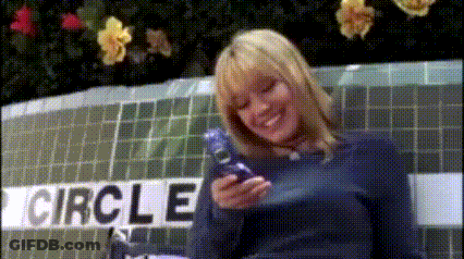 A Woman Standing In Front Of A Circle Sign GIF