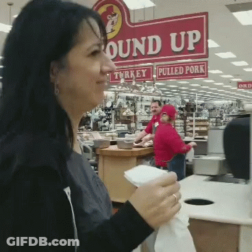 A Woman Standing In Front Of A Sign That Says " Round Up " GIF