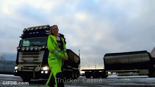 A Woman Standing In Front Of A Truck That Says Trucker Cassie On The Bottom GIF
