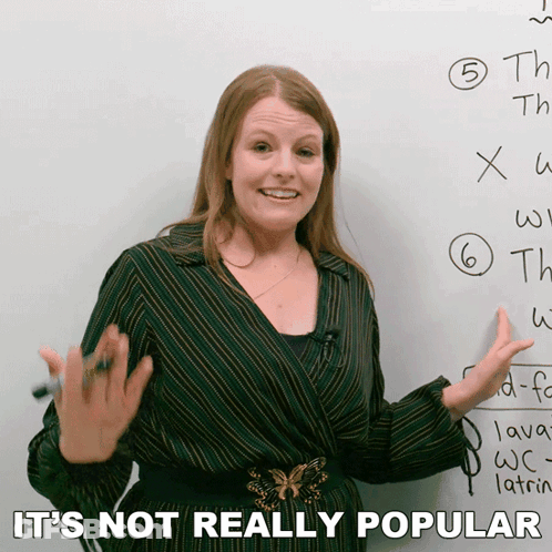 A Woman Standing In Front Of A White Board With The Words " It 'S Not Really Popular " On The Bottom GIF