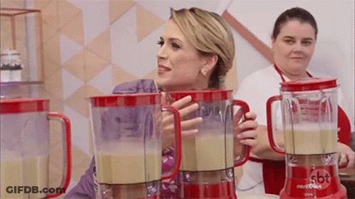 A Woman Standing Next To A Blender That Says Sbt GIF