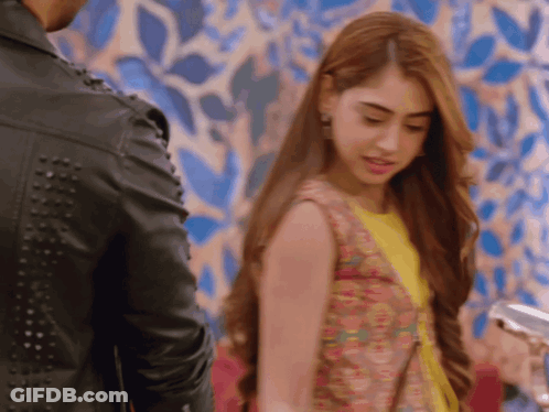 A Woman Standing Next To A Man In A Black Leather Jacket GIF