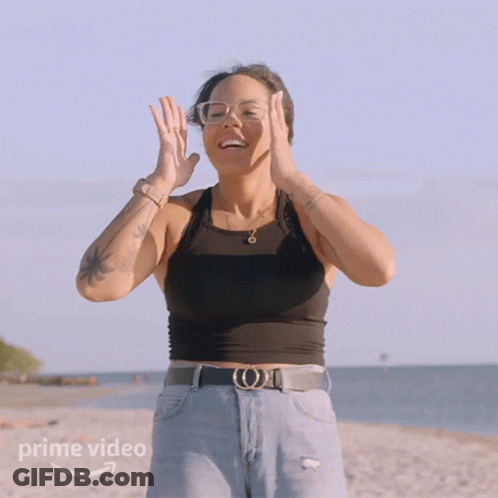 A Woman Standing On A Beach With A Prime Video Logo On The Bottom GIF