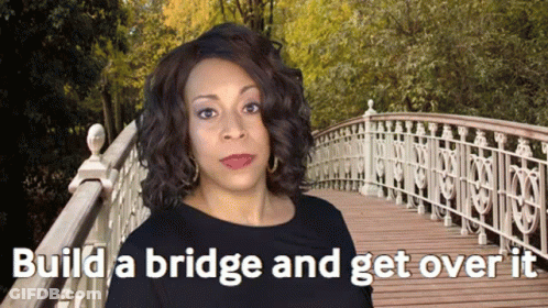 A Woman Standing On A Bridge With The Words " Build A Bridge And Get Over It " GIF