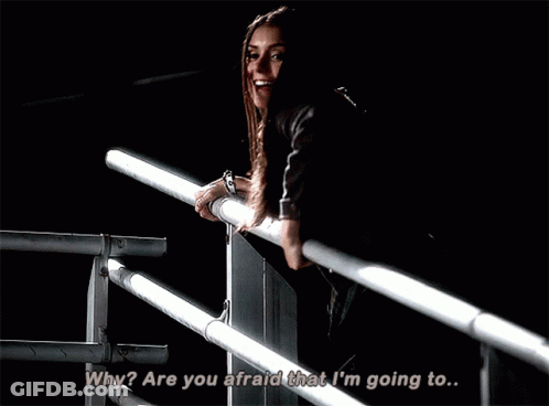 A Woman Standing On A Railing With The Words " Why Are You Afraid That I 'M Going To " GIF