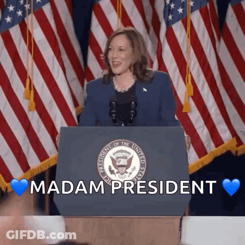 A Woman Stands Behind A Podium With The Words " Madam President " Written On It GIF