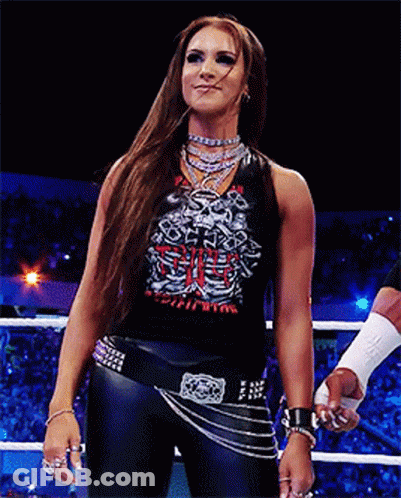 A Woman Stands In A Wrestling Ring Wearing A Shirt That Says Skeleton GIF