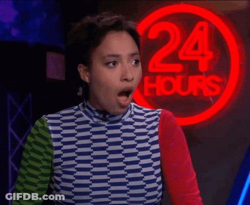 A Woman Stands In Front Of A 24 Hours Neon Sign GIF