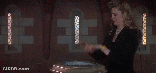 A Woman Stands In Front Of A Baptismal Font GIF