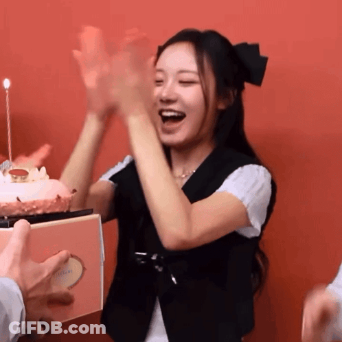 A Woman Stands In Front Of A Birthday Cake With A Candle GIF