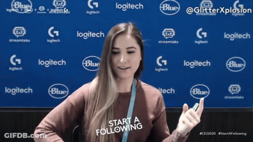 A Woman Stands In Front Of A Blue Background With Logitech And Blue Logos GIF
