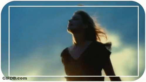 A Woman Stands In Front Of A Blue Sky GIF