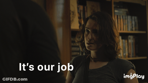A Woman Stands In Front Of A Bookshelf With The Words It 'S Our Job Below Her GIF