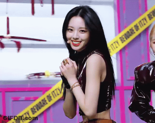 A Woman Stands In Front Of A Caution Tape That Says Itzy Beware Of Itzy GIF