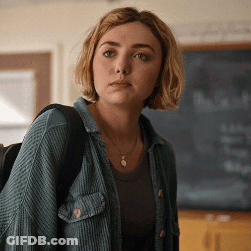 A Woman Stands In Front Of A Chalkboard That Says " The Truth " On It GIF