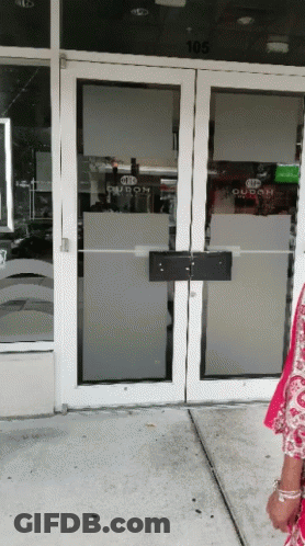 A Woman Stands In Front Of A Door That Says Duban GIF