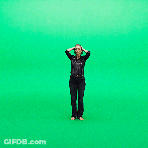 A Woman Stands In Front Of A Green Screen GIF