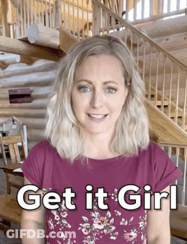 A Woman Stands In Front Of A Log Cabin With The Words Get It Girl Written On Her Shirt GIF