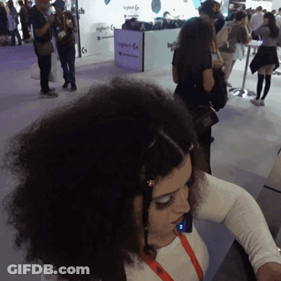 A Woman Stands In Front Of A Logitech Display GIF